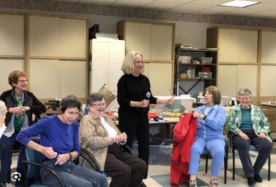 A small group of residents laughing together during an improv activity in a community room