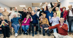 Residents laughing and cheering with arms raised during a hands-on improv activity
